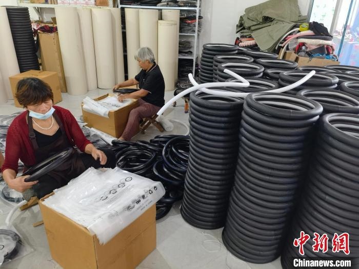 圖為村民在汽車飾品企業(yè)生產(chǎn)車間中工作?！巫雍?攝