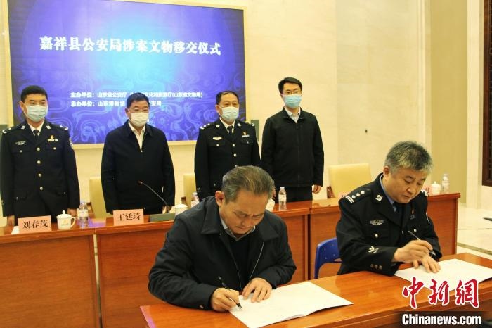 山東博物館館長鄭同修和嘉祥縣人民政府副縣長、公安局局長趙健簽署移交協(xié)議。　趙曉 攝