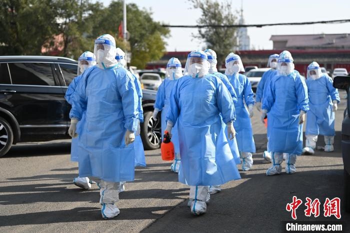 圖為醫(yī)務(wù)人員在封閉小區(qū)做防控工作?！⑽娜A 攝