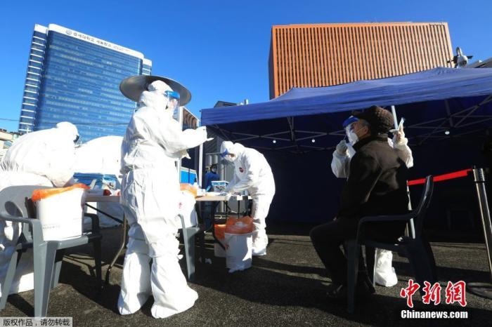 資料圖：韓國(guó)首爾，醫(yī)務(wù)人員對(duì)市民進(jìn)行新冠病毒檢測(cè)。