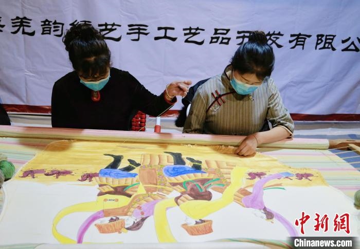 圖為皮繡藝人在市集上“秀”指尖技藝?！●R銘言 攝