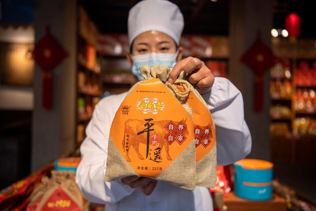 1月27日，在平遙古城南大街的一家平遙牛肉店內(nèi)，工作人員展示一款牛肉產(chǎn)品。新華社記者 楊晨光 攝