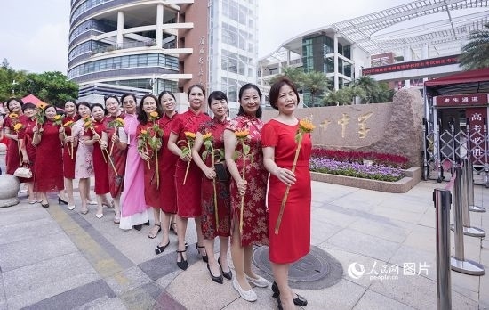 6月7日一早，廈門雙十中學(xué)考生家長(zhǎng)們身穿旗袍，手拿向日葵在考場(chǎng)外為孩子加油打氣，寓意“旗開(kāi)得勝，一舉奪魁”。人民網(wǎng)記者 陳博攝