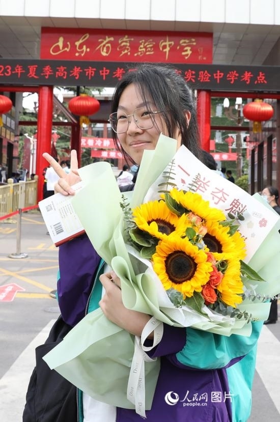 6月7日高考首日，山東67萬(wàn)考生走進(jìn)考場(chǎng)，拼搏逐夢(mèng)。在山東省實(shí)驗(yàn)中學(xué)考點(diǎn)，考生進(jìn)考場(chǎng)前手捧向日葵花拍照留念，寓意“一舉奪魁”。人民網(wǎng)記者 劉祺攝