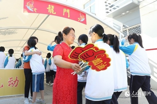 6月7日一早，雄安新區(qū)安新中學(xué)老師在給同學(xué)們加油鼓勁兒。人民網(wǎng) 李兆民攝