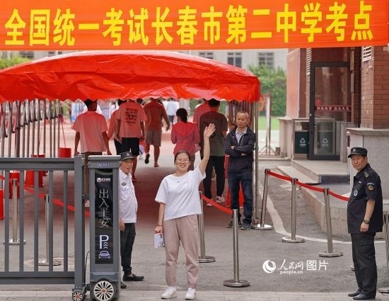 6月7日，在長(zhǎng)春市第二中學(xué)考點(diǎn)，一名考生信心滿滿進(jìn)入考場(chǎng)，并與家長(zhǎng)揮手致意。人民網(wǎng)記者 李洋攝