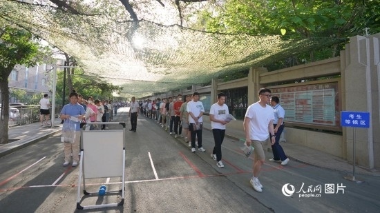 6月7日，烏魯木齊市第七十中學(xué)門口，考生們有序進(jìn)入考場(chǎng)。人民網(wǎng) 李欣洋攝