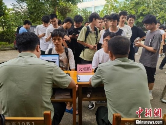 專武干部在發(fā)放兵役登記證。韋碩 攝