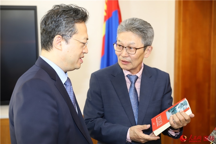 其米德策耶（右一）向李峙介紹翻譯成果。人民網(wǎng)記者 霍文攝