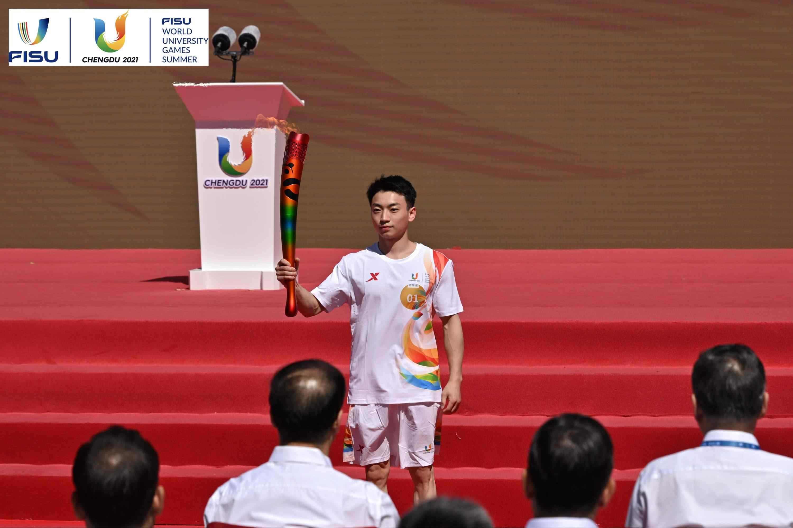 成都大運會火炬手、奧運冠軍鄒敬園高舉火炬。 圖片來源：成都大運會執(zhí)委會供圖