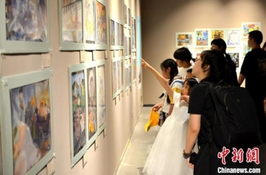 圖為家長帶著孩子參觀展覽。呂明 攝