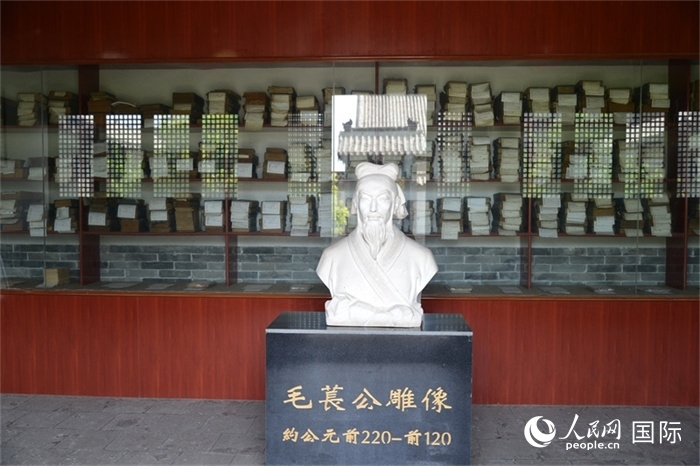 河間詩(shī)經(jīng)齋毛萇雕像。雕像后書櫥中陳列的是歷代各版本《詩(shī)經(jīng)》及譯本。 人民網(wǎng) 趙昭攝