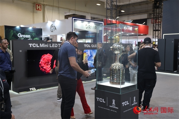 參觀者在TCL展臺(tái)前觀看南美解放者杯獎(jiǎng)杯，據(jù)介紹，TCL是南美解放者杯（2023—2026賽季）全球官方合作伙伴。（人民網(wǎng)記者 時(shí)元皓攝）