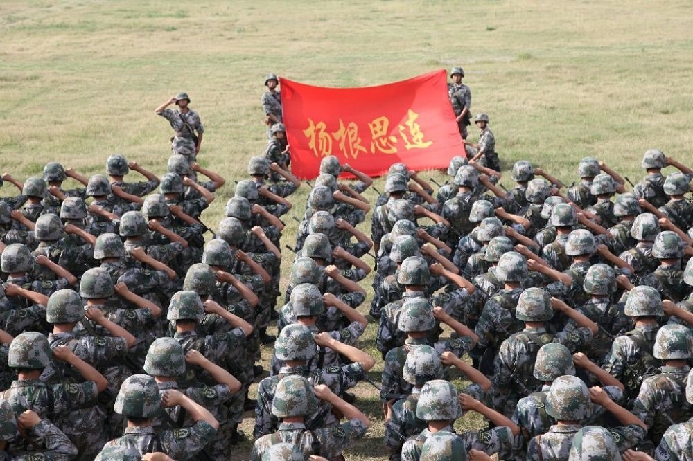 ↑“楊根思連”官兵執(zhí)行任務(wù)前向連旗宣誓（資料照片）。新華社發(fā)