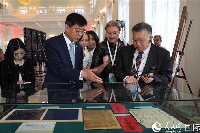 中俄圖書館論壇嘉賓共同參觀由俄羅斯國立列寧圖書館舉辦的館藏中國古籍善本圖書展。人民網(wǎng)記者 隋鑫攝）