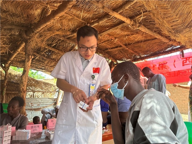 圖為南昌大學(xué)第一附屬醫(yī)院病理科主治醫(yī)師張振東為村民解說(shuō)藥品使用方法。中國(guó)駐乍得醫(yī)療隊(duì)供圖