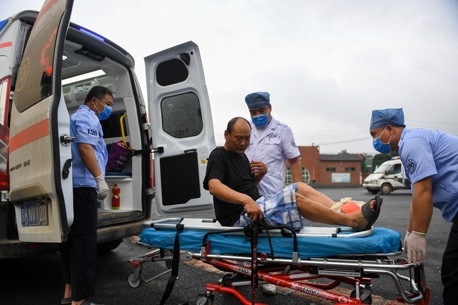 8月1日，在北京市門頭溝區(qū)妙峰山鎮(zhèn)妙峰山民族學校臨時安置點，北京急救中心工作人員在轉運一名受傷村民。新華社記者 鞠煥宗 攝