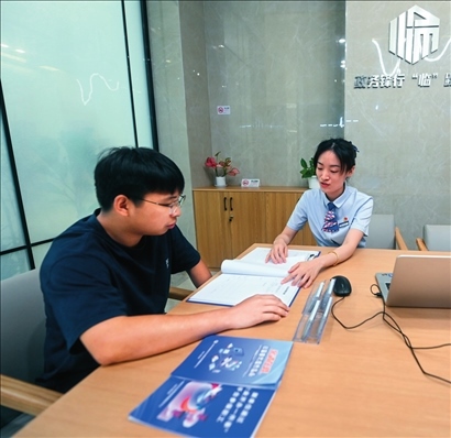 在杭州市臨安區(qū)政務(wù)服務(wù)中心的“為企服務(wù)中心”，黨員志愿者（右）解答企業(yè)主的疑問（2023年7月7日攝）。徐昱攝/本刊