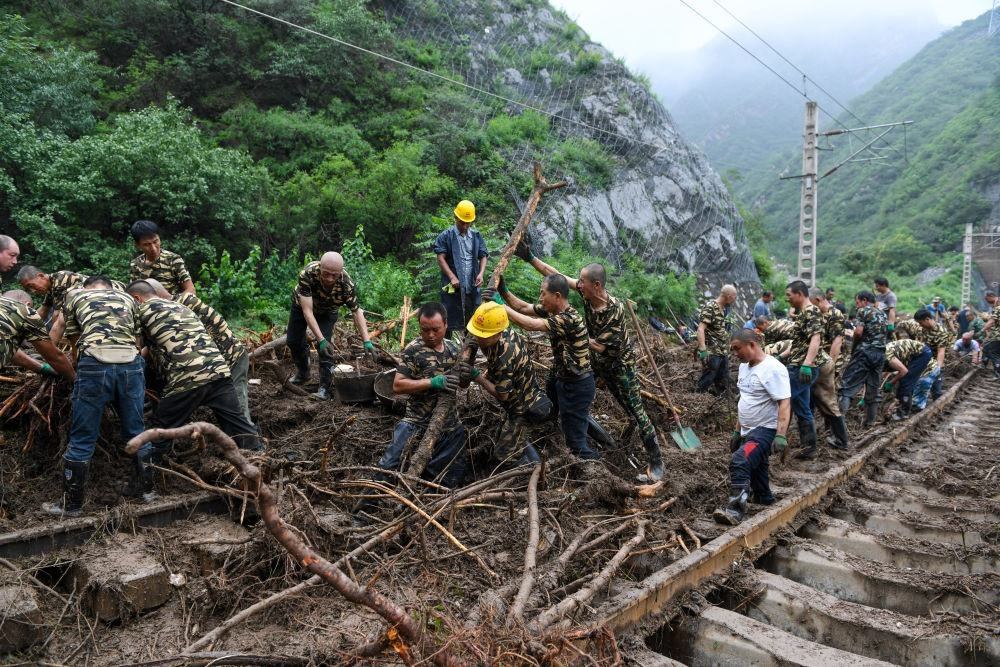 8月1日，在北京市門頭溝區(qū)水峪嘴村附近一段被阻斷的鐵路線上，中鐵六局工作人員在清理軌道上的雜物，全力恢復(fù)交通。新華社記者 鞠煥宗 攝