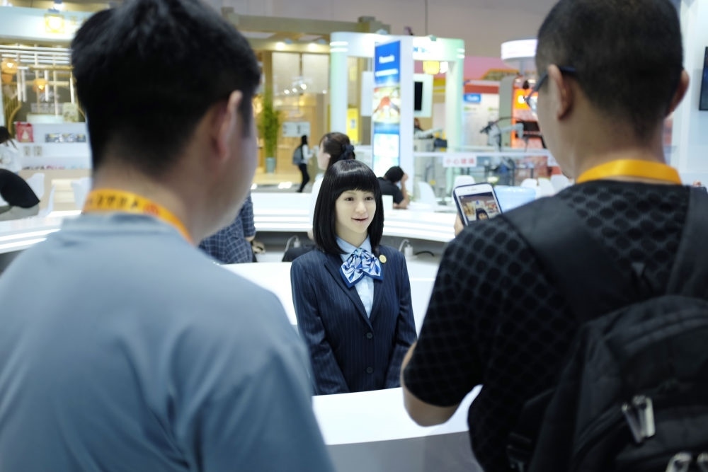 9月1日，媒體記者在國家會(huì)議中心與服務(wù)機(jī)器人互動(dòng)。新華社記者 劉夢(mèng)琪 攝