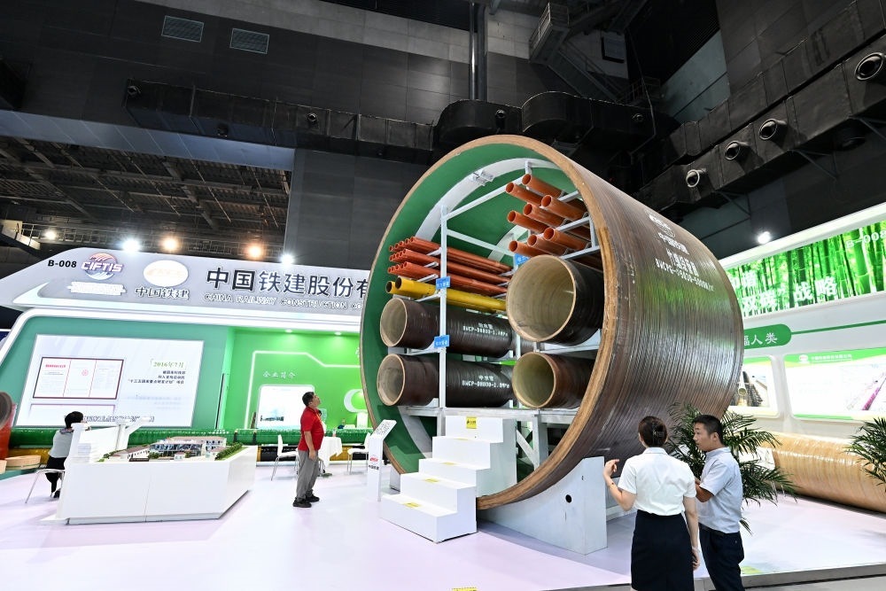 9月2日，在國(guó)家體育館舉行的服貿(mào)會(huì)環(huán)境服務(wù)專題展上，客商在中國(guó)鐵建展位竹纏繞管廊旁了解信息。新華社記者 李鑫 攝