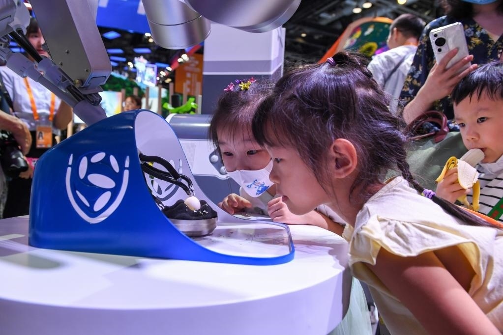 9月3日，幾名小朋友在國家會(huì)議中心觀看單孔腔鏡手術(shù)機(jī)器人展示。新華社記者 鞠煥宗 攝