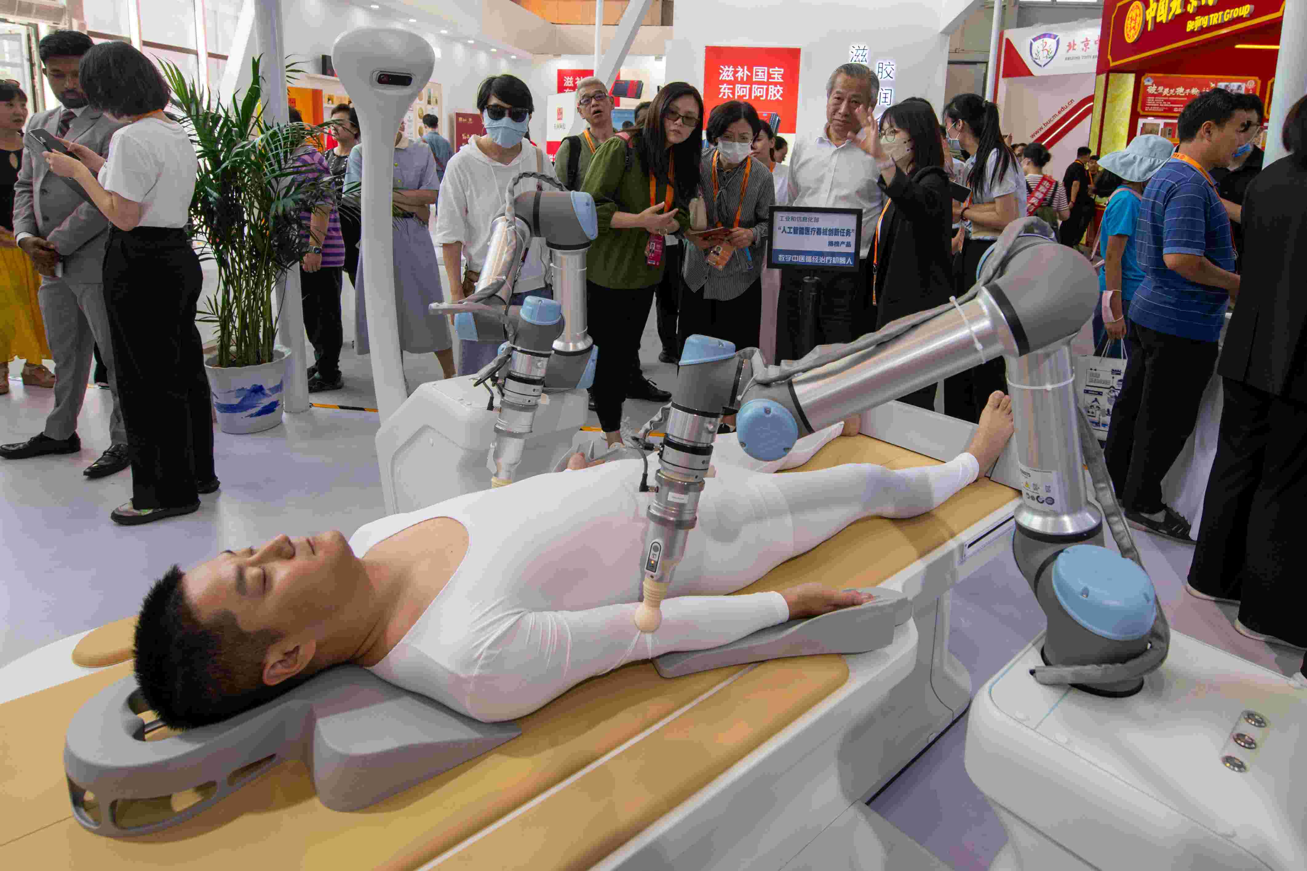 在位于首鋼園的健康衛(wèi)生服務(wù)展區(qū)，觀眾正在參觀數(shù)字中醫(yī)循經(jīng)治療機器人。人民網(wǎng)記者 翁奇羽攝