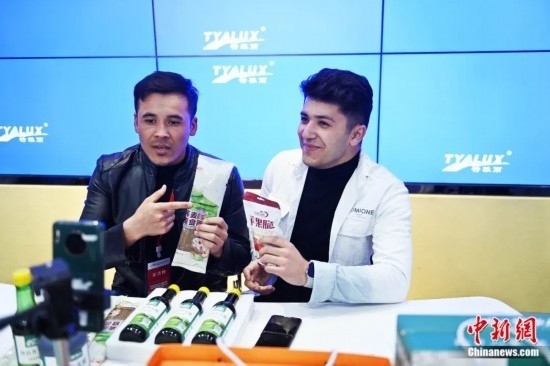 2023年3月，甘肅省慶陽市環(huán)縣電商創(chuàng)業(yè)孵化基地內(nèi)，來自蘭州文理學(xué)院的塔吉克斯坦留學(xué)生正在協(xié)助主播直播帶貨當(dāng)?shù)剞r(nóng)特產(chǎn)品。李亞龍 攝