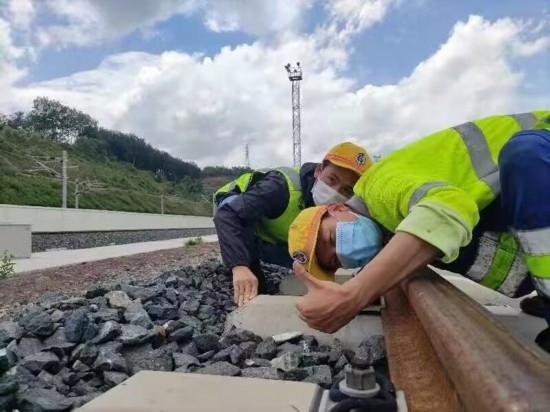 佟郎（左）正在檢修鐵路。受訪者供圖