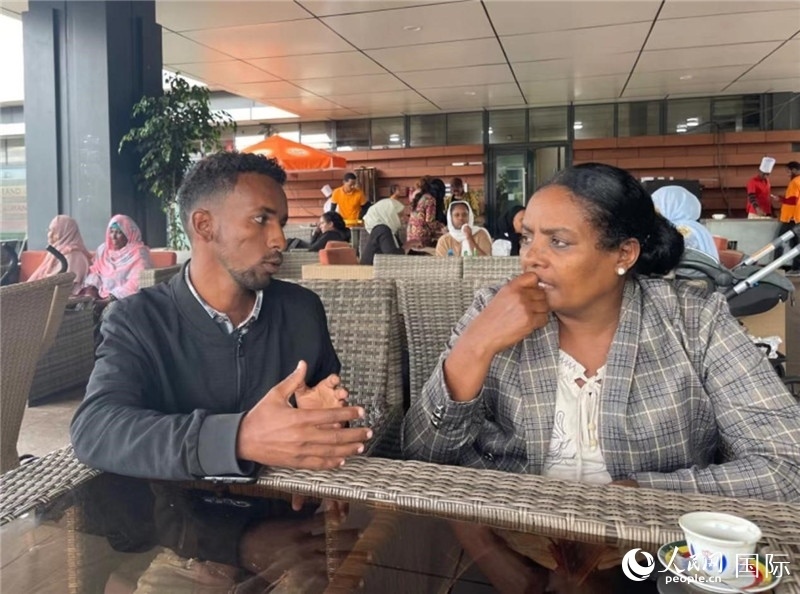 約漢斯（圖左）與德貝拉在友誼廣場(chǎng)咖啡廳交談。人民網(wǎng)記者 趙艷紅攝