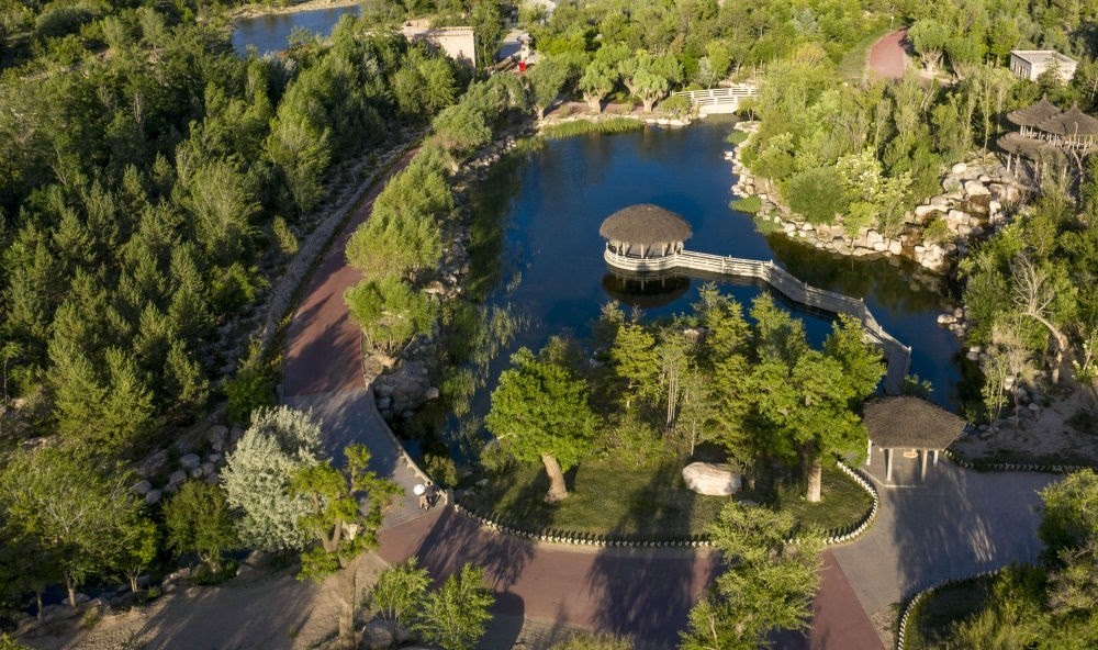 坐落在寧夏銀川市賀蘭山腳下的賀蘭山運(yùn)動(dòng)休閑公園（2021年5月27日攝，無(wú)人機(jī)照片）。這里曾是一片砂石采礦塌陷區(qū)，當(dāng)?shù)赝ㄟ^(guò)植被景觀再造、水系建設(shè)、現(xiàn)代管網(wǎng)鋪建等手段，重新利用廢石、廢坑及各類廢棄建筑材料，把這里變成一座免費(fèi)開(kāi)放的主題公園。新華社記者 馮開(kāi)華 攝