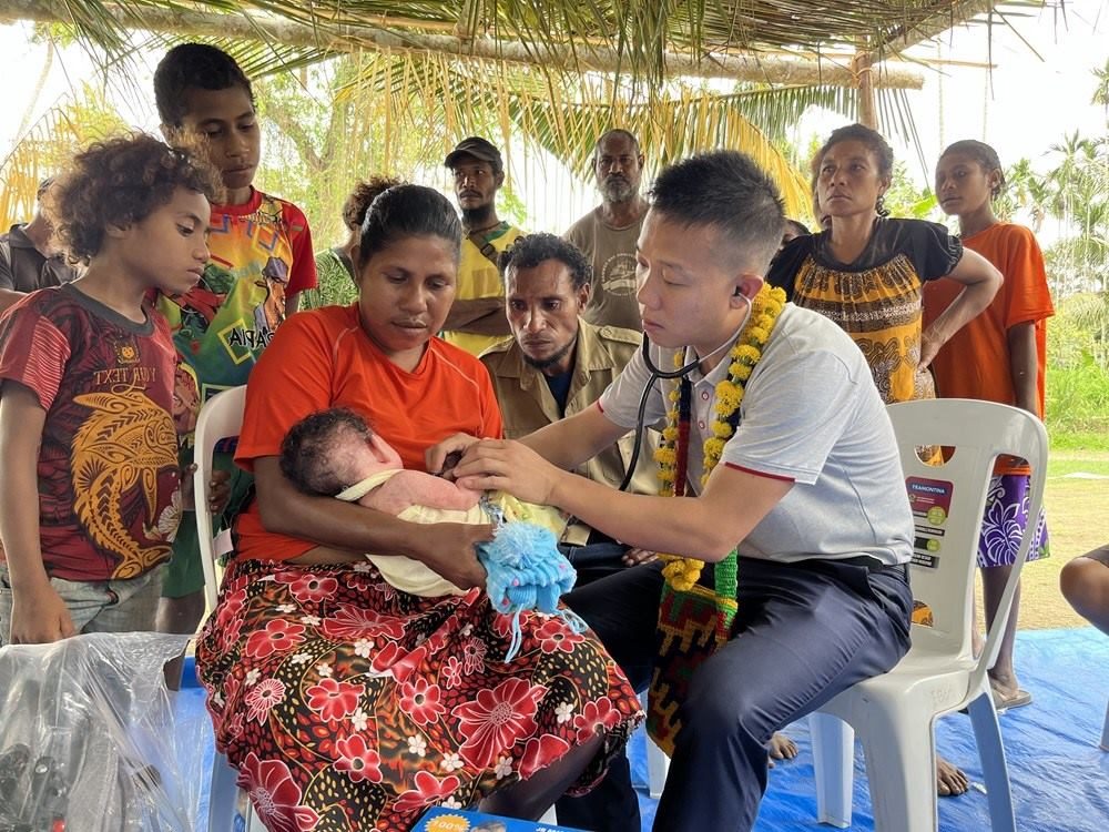 2023年8月5日，在巴布亞新幾內(nèi)亞中央省的一個(gè)村莊里，第12批援巴新中國醫(yī)療隊(duì)副隊(duì)長、新生兒科副主任醫(yī)師劉振球?yàn)楫?dāng)?shù)貗雰郝犜\檢查。新華社發(fā)（第12批援巴新中國醫(yī)療隊(duì)供圖）