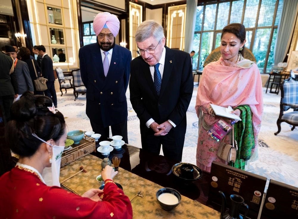 △歡迎宴會前，亞奧理事會代理主席辛格和夫人維尼塔、國際奧委會主席巴赫欣賞非遺展示。