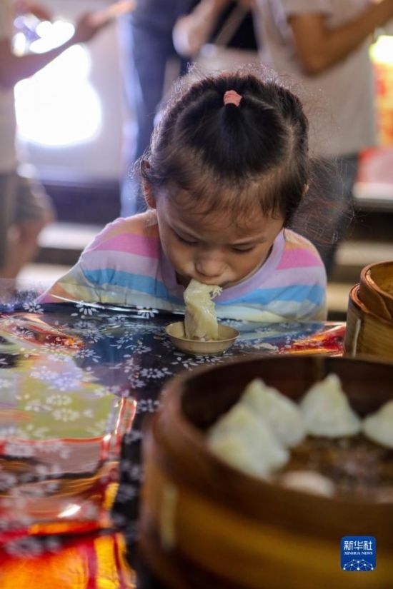 9月27日，小朋友在南翔小籠長街宴上品嘗南翔小籠。