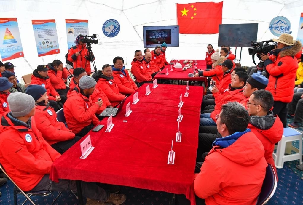 海拔4950米的卓奧友峰科考大本營，科考隊員趙華標（手拿麥克風看電腦者）在宣讀剛剛接收到的頂峰氣象觀測數(shù)據(jù)，這標志著峰頂自動氣象站架設(shè)成功，成功傳回觀測數(shù)據(jù)（10月1日攝）。新華社記者晉美多吉 攝