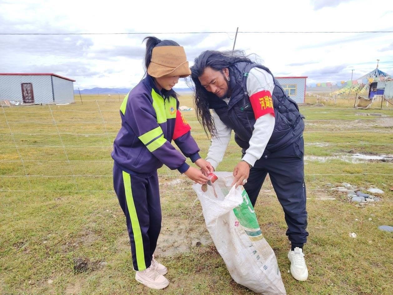 玉樹州稱多縣珍秦鎮(zhèn)河湖志愿者才培和他女兒更求拉毛在清掃垃圾。受訪者供圖