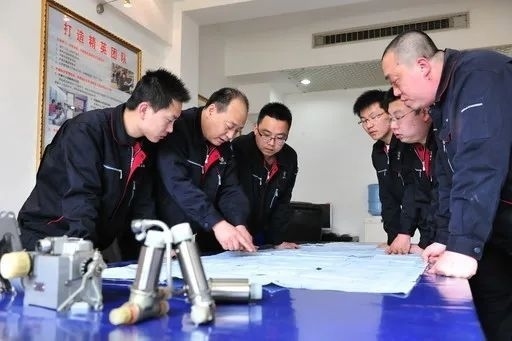 △李志強(qiáng)（左二）與班組成員在研究工作。