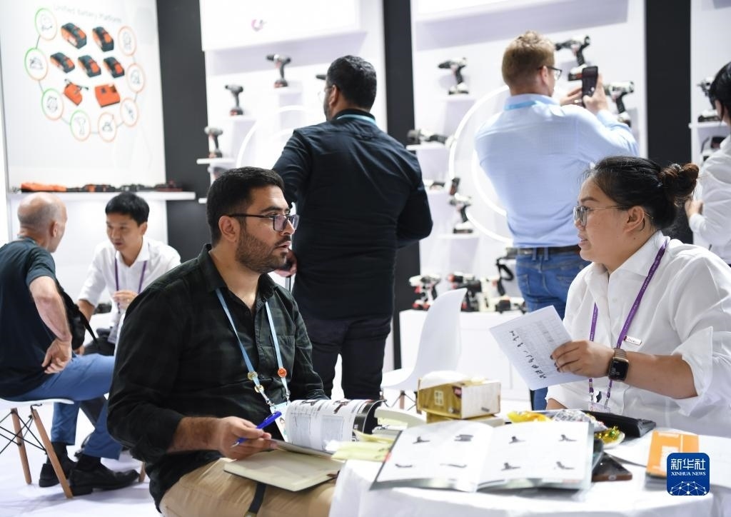 10月15日，在一家電動工具展臺，外國采購商在洽談業(yè)務。新華社記者 鄧華 攝