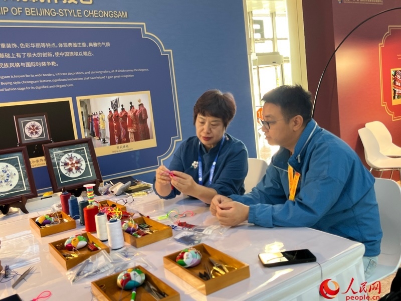 記者在新聞中心非遺傳承人展區(qū)進(jìn)行體驗(yàn)。人民網(wǎng)記者 杜燕飛攝