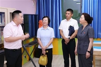 圖③：“小公民法律課堂”開講前，全國人大代表殷其龍（右二）、重慶市人大代表李自玲（左二）聽取楊家坪中學負責人關于未成年人思想教育工作情況的介紹。