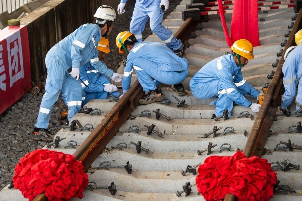 3月31日，在印度尼西亞雅加達雅萬高鐵哈利姆車站，工人鋪設(shè)雅萬高鐵全線最后一根鋼軌。