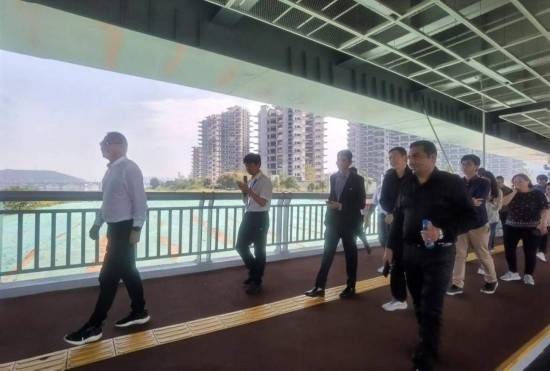 10月24日，2023“一帶一路”媒體合作論壇聯(lián)合采訪團(tuán)團(tuán)員走在清水塘大橋景觀通道上。本報(bào)記者 常雯宜攝