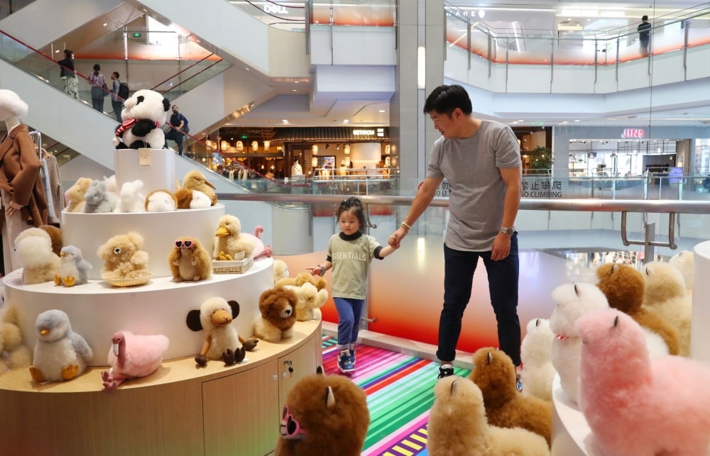 2023年11月2日，顧客在溫暖駝品牌專柜內(nèi)選購。連續(xù)六年參加進(jìn)博會的秘魯羊駝制品品牌溫暖駝在上海市中心商場開設(shè)了專柜。新華社記者 方喆 攝