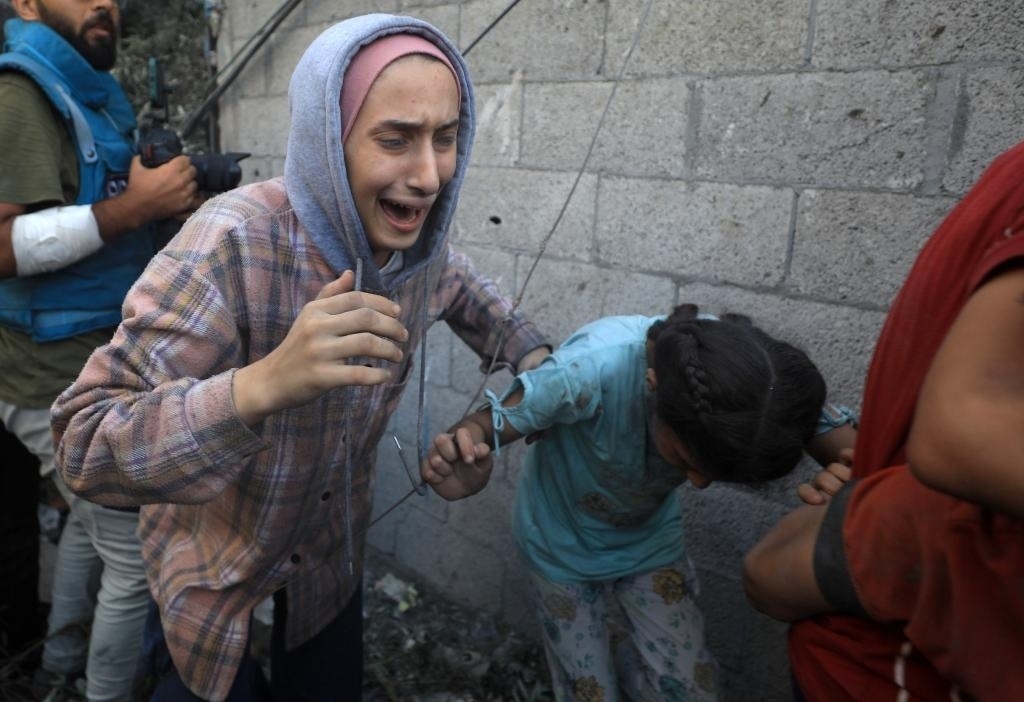 11月6日，人們從加沙地帶中部地區(qū)一處被炸難民營逃離。新華社發(fā)（亞西爾·庫迪攝）