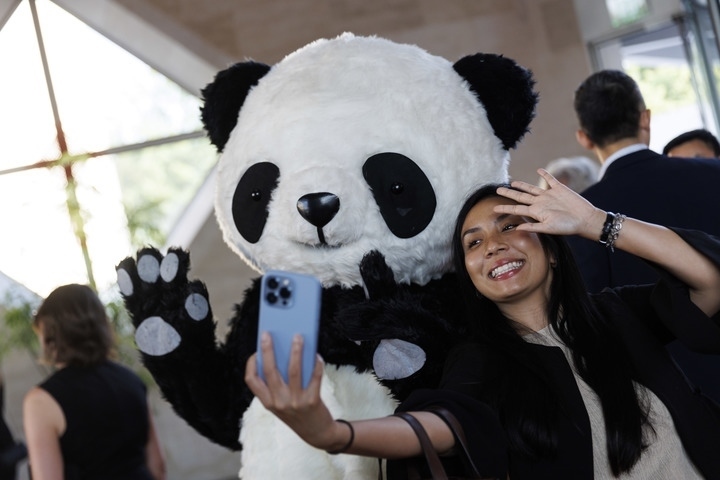 2022年8月24日，在美國(guó)華盛頓中國(guó)駐美國(guó)大使館，來(lái)賓與大熊貓玩偶合影。
