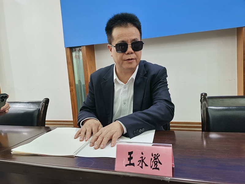 全國人大代表王永澄正在閱讀盲文版代表建議答復(fù)。本報(bào)記者 張 璁?dāng)z