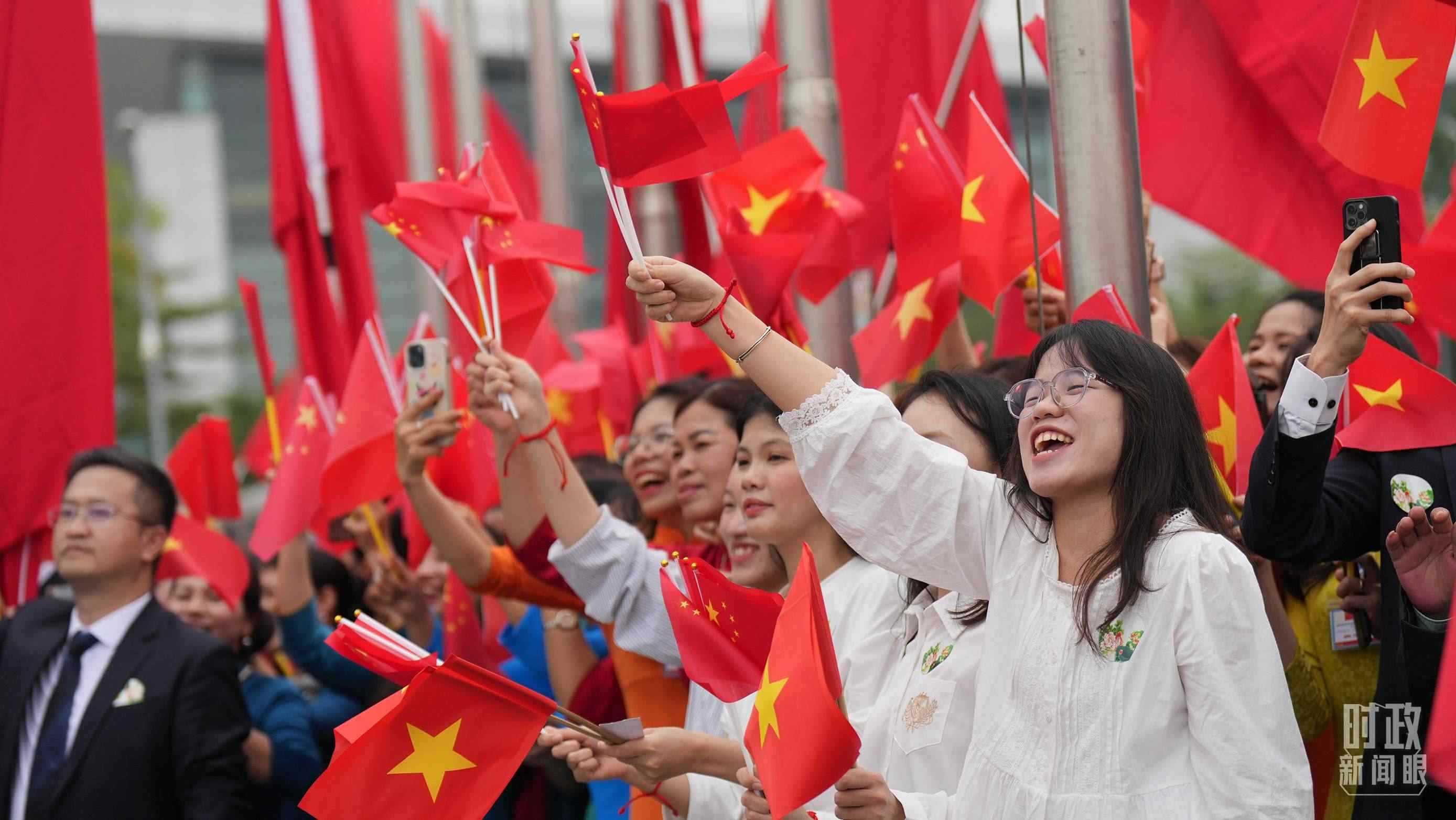 △人們揮舞兩國旗幟歡迎習(xí)近平訪越。（總臺國廣記者李晉拍攝）