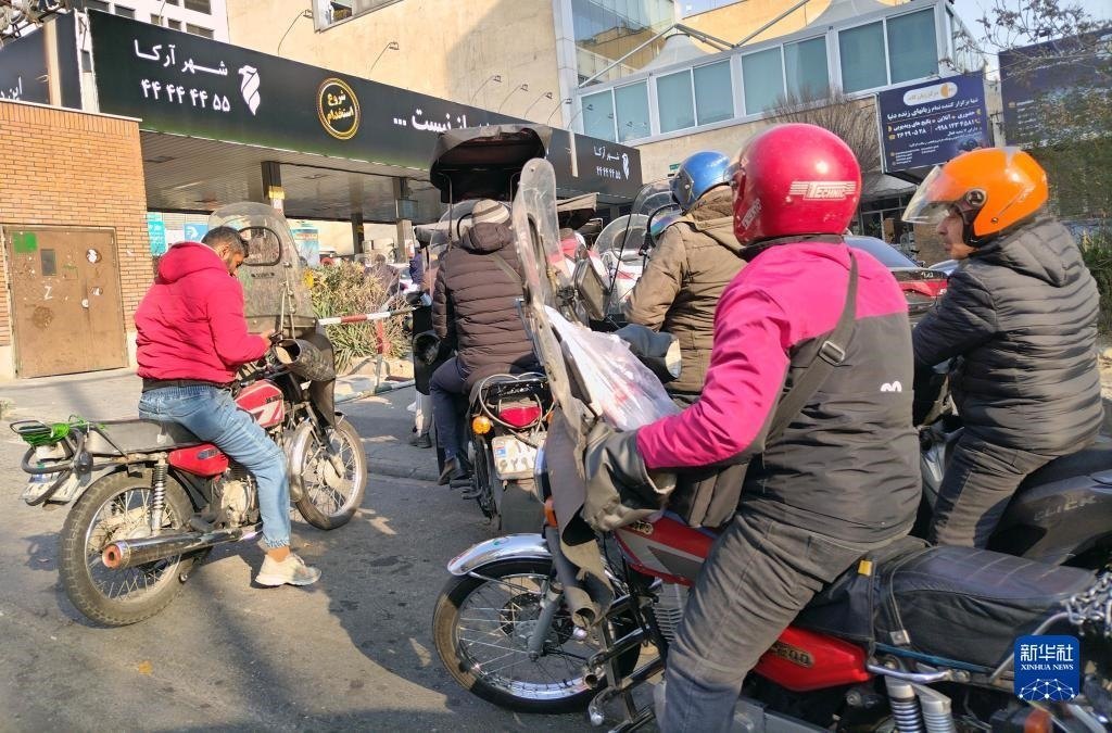 12月18日，摩托車在伊朗首都德黑蘭的一家加油站外等待加油。新華社記者 沙達(dá)提 攝