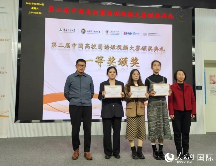 澳門大學(xué)中葡雙語教學(xué)暨培訓(xùn)中心主任姚京明（左一）和中國傳媒大學(xué)外國語言文化學(xué)院院長文春英（右一）為一等獎(jiǎng)獲得者頒獎(jiǎng)。人民網(wǎng)記者 魯揚(yáng)攝