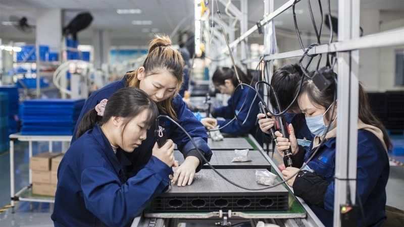 在新亞勝光電的產(chǎn)品線上，工人正進(jìn)行產(chǎn)品組建和安裝布線。受訪者供圖